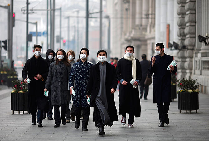 A group of expatriates walk along the Bund as they distribute face masks to pedestrians to raise awareness of air pollution in downtown Shanghai in this January 24, 2013 Reuters file photo.  