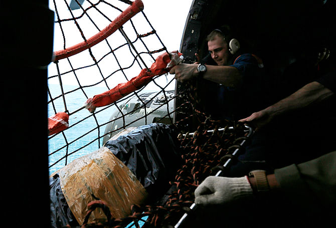 A Russian search team member holds a sack of food, to be transported to his colleagues in a Russian ship, during a search operation for passengers onboard AirAsia Flight QZ8501, off the Java sea, in Indonesia January 7, 2015. Photo: Reuters
