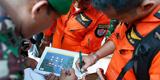 Indonesian military pilots look at a flight plan before setting out for a search mission for AirAsia's Flight QZ8501 in Pangkal Pinang, Bangka island December 30, 2014. Photo: Reuters