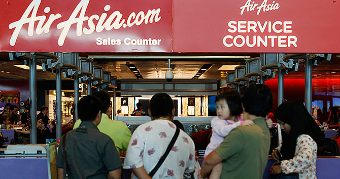 People queue at an AirAsia counter at Changi Airport in Singapore December 28, 2014. Indonesia's Transport Ministry official Hadi Mustofa said an AirAsia aircraft, flight number QZ 8501from Indonesian city of Surabaya to Singapore, lost contact with the Jakarta air traffic control tower on Sunday at 6:17 am local time (2317 GMT). Photo: Reuters