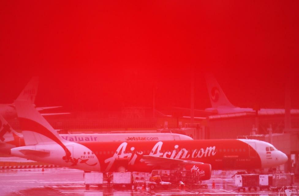 Staff members unload AirAsia's QZ8501 from Surabaya to Singapore, which took the same code as the missing plane that took off 24 hours earlier, after it landed at Changi Airport in Singapore, December 29, 2014. Photo: Reuters