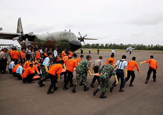 Indonesian Search and Rescue and security forces run to greet helicopters transporting the bodies of AirAsia QZ8501 passengers recovered from the sea at the airport in Pangkalan Bun, Central Kalimantan January 3, 2015. Photo: Reuters