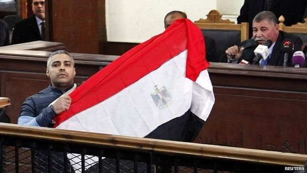 Mohamed Fahmy unfurled an Egyptian flag after testifying he was forced to give up his Egyptian citizenship. Photo: Reuters