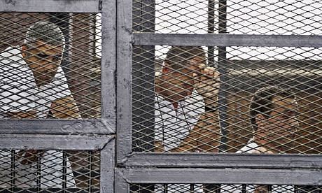 Mohamed Fahmy, Peter Greste and Baher Mohamed in a defendants' cage. Photo: AP
