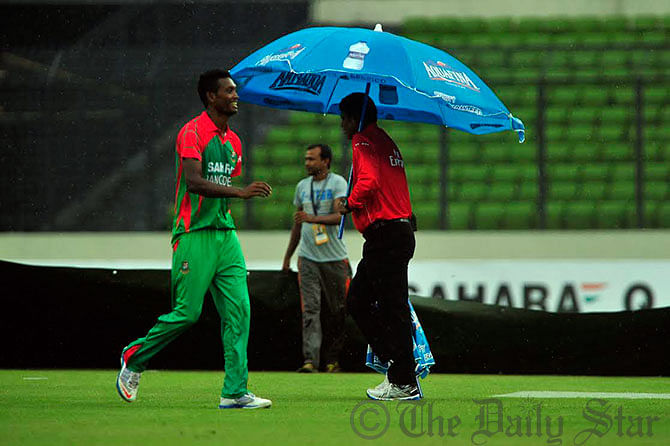 Seamer Al Amin Hossain walks toward the pavillion as rain interrupted the second One Day International between Bangladesh and India at Mirpur Stadium on Tuesday. Photo: Firoz Ahmed