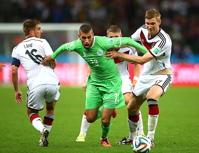 Islam Slimani of Algeria is challenged by Philipp Lahm (L) and Per Mertesacker of Germany during the 2014 FIFA World Cup Brazil Round of 16 match between Germany and Algeria at Estadio Beira-Rio on June 30, 2014 in Porto Alegre, Brazil. Photo: Getty Images