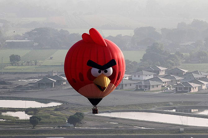 An Angry Bird inspired Hot Air balloon floats over rice fields and houses during the Philippine International Balloon festival in Lubao town, Pampanga province, north of Manila on Thursday. An estimated 30 hot air balloons participated in the event which aims to promote tourism in the Southeast Asian country, local media reported.  Photo: Reuters