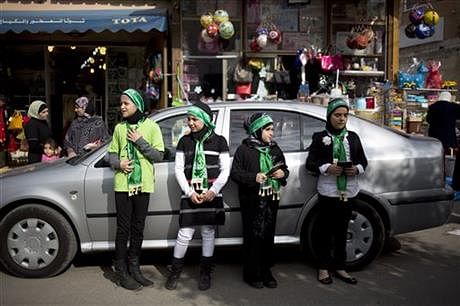 In this Thursday, Jan. 9, 2014, file photo, Israeli Arab girls look for passing cars to hand out Muslim prayer books to in the main street in the Arab town of Taybeh, central Israel. Photo: AP