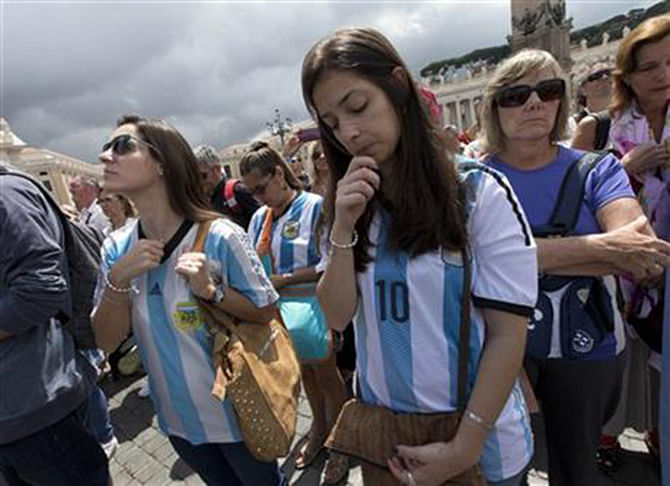 Faithful wearing Argentina soccer team jerseys pray as Pope Francis delivers the Angelus prayer in St. Peter square at the Vatican, Sunday, July 13. Photo: AP 