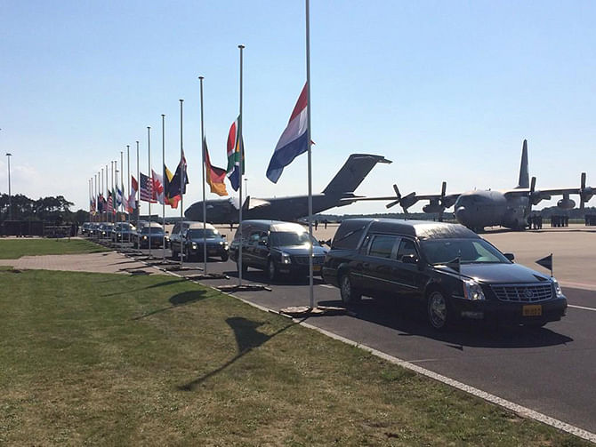 Hearses with MH17 victims coffins leave the tarmac next to the flags of the victim's nations at half-mast in the Netherlands on Wednesday, July 23, 2014. Photo taken from Twitter
