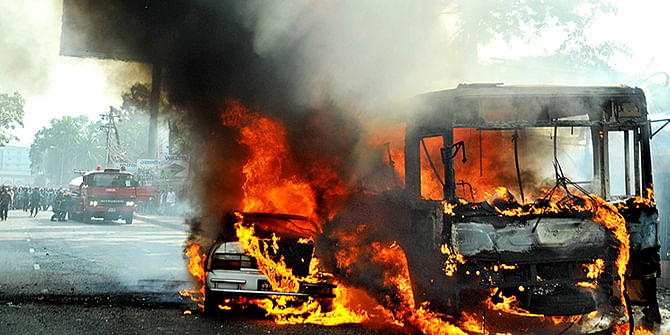 A private car and a state-run BRTC bus burning near Rajuk Bhaban at Gulistan on Tuesday, January 06, 2015. Photo: Star
