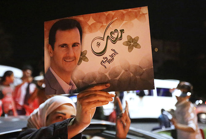 A woman holds a picture of re-elected Syrian President Bashar al-Assad as she celebrates in Damascus after he was announced as the winner of the country's presidential elections on June 4, 2014. Photo: Getty Images