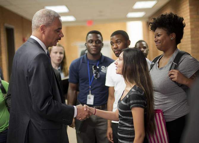 Attorney General Eric Holder shakes hands with Bri Ehsan, 25, following his meeting with students at St Louis Community College Florissant Valley in Ferguson, Missouri August 20, 2014. Photo: Reuters