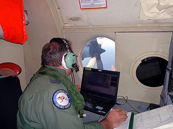 A Royal Australian Air Force crew member of an AP-3C Orion maritime patrol aircraft scans the surface of the sea near the west of Peninsula Malaysia in this handout picture by the Royal Australian Air Force, released via the Australian government's Department of Defence website on March 17. Photo: Reuters