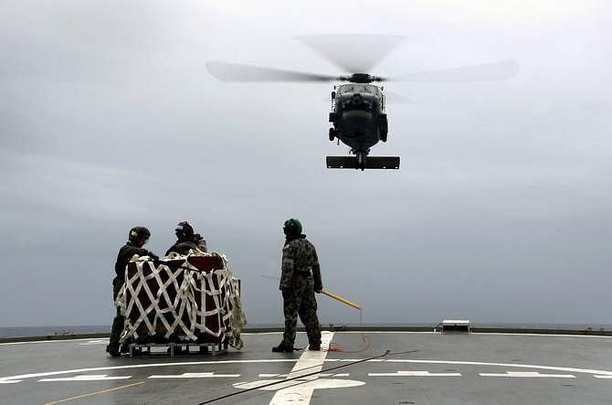 A S-70B-2 Seahawk (Tiger 75) helicopter makes an approach to the flight deck of Australian Navy ship HMAS Toowoomba to pick up supplies during a vertical replenishment at sea with HMAS Success as they continue to search for the missing Malaysian Airlines flight MH370 in this picture released by the Australian Defence Force April 6, 2014.