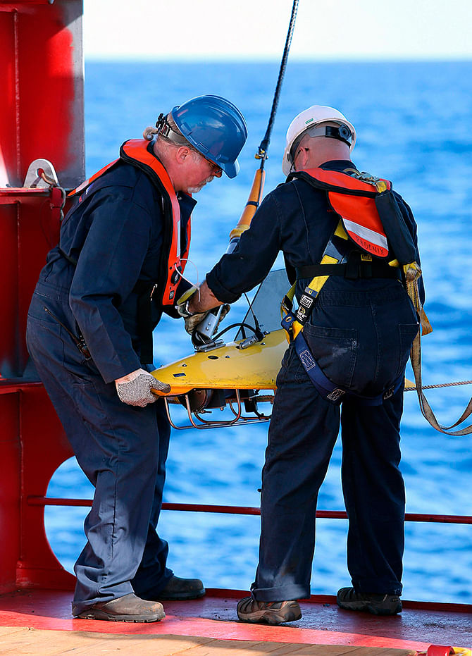 Phoenix International personnel, Mike Unzicker an0d Chris Minor deploy the towed pinger locator off the deck of the Australian Defence Vessel Ocean Shield in the southern Indian Ocean during the search for the flight data recorder and cockpit voice recorder of the missing Malaysian Airlines flight MH370 in this picture released by the Australian Defence Force yesterday. Photo: Reuters