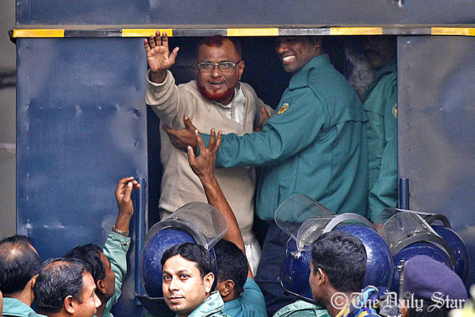 War criminal ATM Azharul Islam waving to onlookers as he is put into a prison van after International Crimes Tribunal-1 awards him death penalty on Tuesday for his crimes against humanity committed during the Liberation War in 1971. Photo: Anisur Rahman
