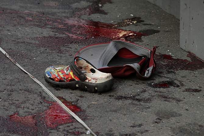 A shoe and a cap are seen near blood stains following a bomb blast in Bangkok on February 23. Photot: Reuters
