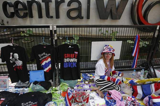 A vendor sells accessories to anti-government protesters at one of their encampment in Bangkok's shopping district Saturday. Photo: Reuters
