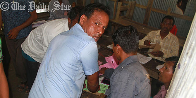Activists of Chhatra League and Jobo League are rigging votes by putting seals on ballot papers during upazila elections at Kalirtabak Dakhil Madrasa polling centre in Barguna upazila of Barisal around 1:15pm on Monday. Photo: Star 