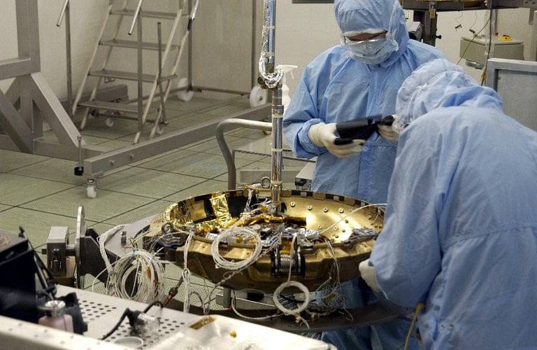 Technicians work on the construction of Beagle 2, a new Mars lander craft, 19 December 2002. A consortium of British Universities, research teams and engineering companies have constructed a new spacecraft that will look for signs of life on the planet Mars. It will be launched from a Soyuz-Fregat rocket in Kazakhstan and is part of the Mars Express mission. Photo: AFP