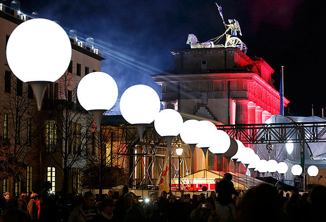 Lit balloons are placed along the former Berlin Wall location near the Brandenburg Gate in Berlin November 8, 2014. A part of the inner city of Berlin will be temporarily divided from November 7 to 9, with a light installation 'Lichtgrenze' (Border of Light) featuring 8000 luminous white balloons to commemorate the 25th anniversary of the fall of the Berlin Wall. Photo: Reuters