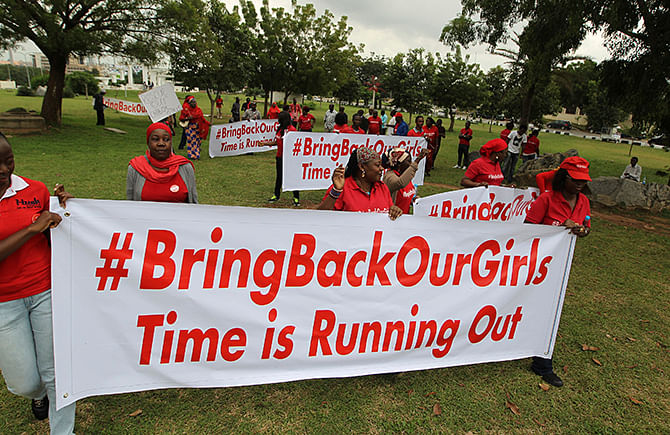 Demonstrators hold up banners during a rally that was held to mark the 120th day since the abduction of two hundred school girls by the Boko Haram, in Abuja August 12, 2014. Photo: Reuters