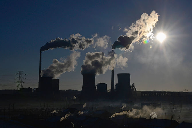 This Reuters photo taken on March 6, 2014 shows smoke rising from chimneys and cooling towers of a thermal power plant during sunrise in Fushun, Liaoning province. 