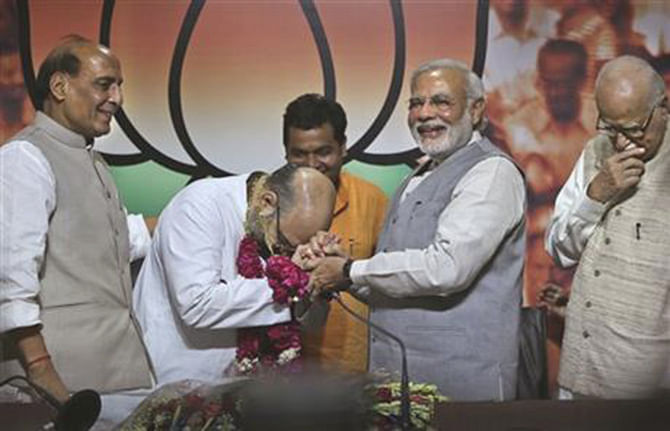 Indian Prime Minister Narendra Modi, second from right, greets newly appointed Bharatiya Janata party or BJP president Amit Shah, second from left, as outgoing party president Rajnath Singh, left, and BJP senior leader L.K.Advani watch, at the party's headquarters in New Delhi, India, Wednesday, July 9, 2014. Photo: AP