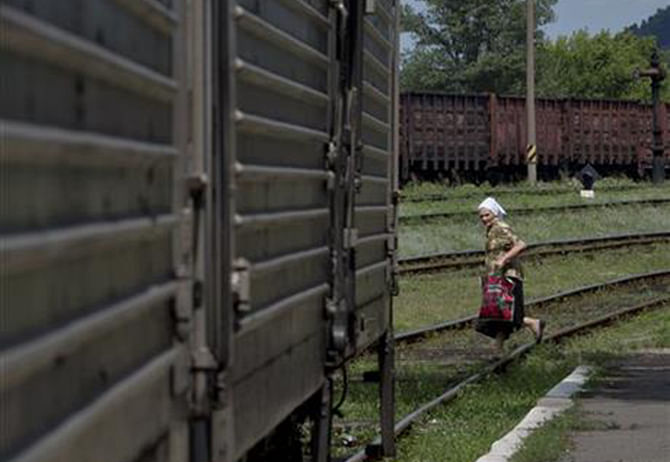 A woman looks at a refrigerated train loaded with the bodies of victims, in Torez, eastern Ukraine, 15 kilometers (9 miles) from the crash site of Malaysia Airlines Flight 17, Sunday. Photo: AP