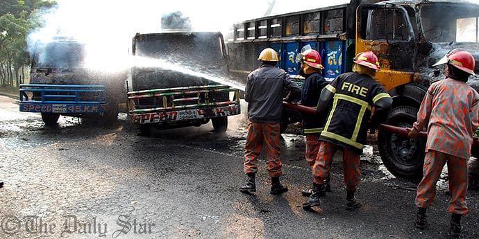 Fire fighters douse the flames after BNP-led opposition blockaders set fire to three trucks on Bogra-Dhaka highway in Radharghat area in Shahjahanpur today.