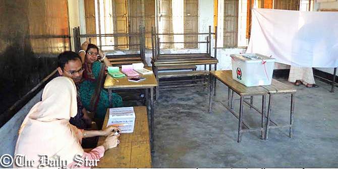 Election officials are seen waiting for voters at Seujgari Primary School polling centre in Bogra Sadar Upazila while a voter is franchising his vote in a secrete place. Photo: Star