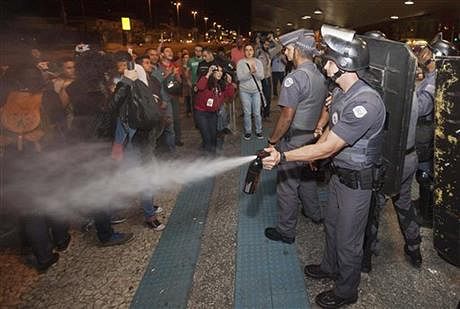 A police officer pepper sprays strikers and protesters during a clash with riot police in front of the Ana Rosa metro station, in an ongoing subway strike by operators, in Sao Paulo, Brazil on Monday. Photo: AP