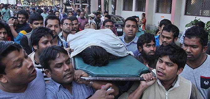 Fellow Chhatra League activists carry the body of Taposh Paul, 20, from CMCH on Sunday. Photo: Star