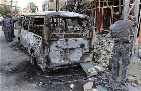 Civilians inspect the site of Friday's car bomb in Baghdad's Gorayaat neighborhood, Iraq, Saturday, November 15, 2014. The nighttime blast in the Gorayaat area was the largest of four bombings in and around the city on Friday, mostly targeting Shi'a areas. Photo: AP