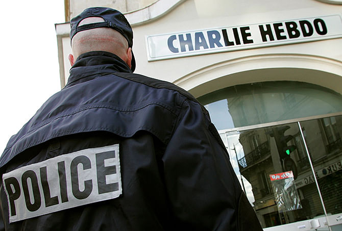 A policeman stands guard outside the French satirical weekly 