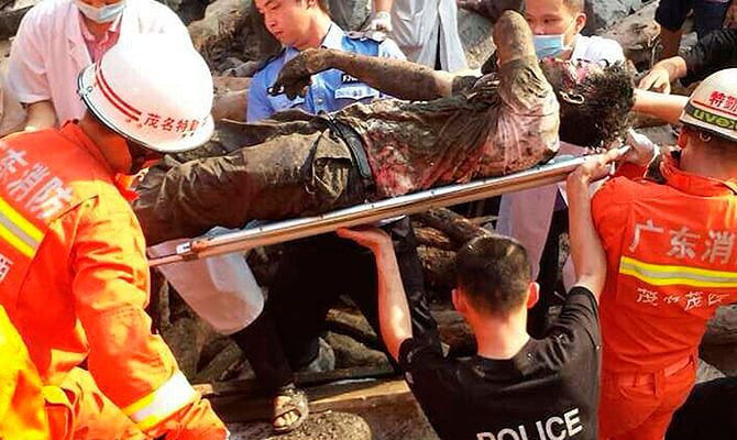 Rescue workers carry an injured man after a bridge collapsed during construction in Maoming, Guangdong province, May 3, 2014. Photo: Reuters