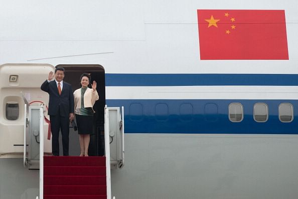 China's President Xi Jinping (L) and his wife Peng Liyuan (R) wave as they disembark from their aircraft upon arrival at Seoul Air Base on July 3, 2014. China's president arrived in Seoul for a state visit seen as a snub to Beijing's traditional ally North Korea, whose nuclear weapons ambitions will dominate talks with South Korean leader Park Geun-Hye. Photo: Getty Images