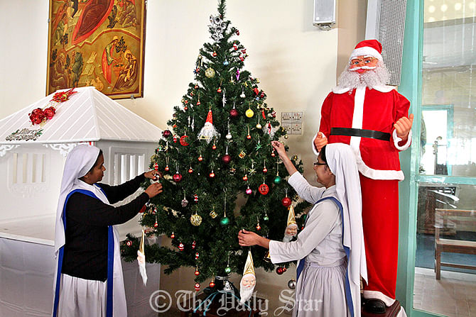 Two sisters decorate an Xmass tree at a church in Tejgaon in the capital on Wednesday. Photo: Anisur Rahman   