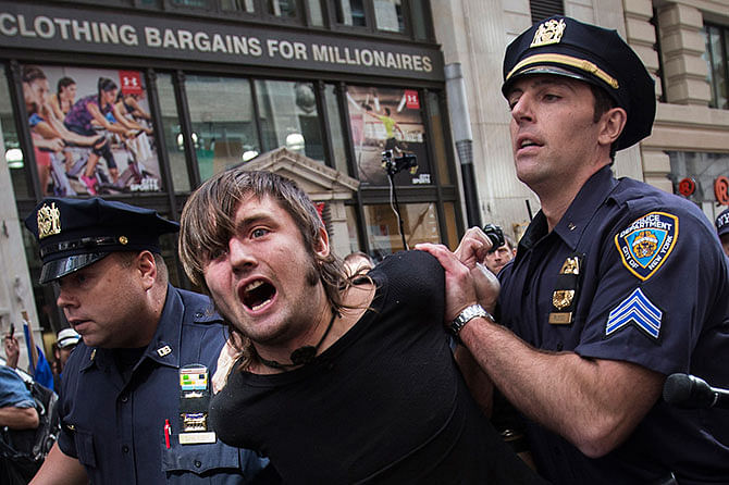 New York City police officers arrest a man taking part in the Flood Wall Street demonstration in Lower Manhattan, New York September 22, 2014. Hundreds of protesters marched through New York City's financial district on Monday to call attention to what organisers say is capitalism's contribution to climate change, snarling traffic and risking arrest as they sought to block Wall Street. Photo: Reuters