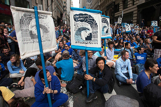 Protesters stage a sit-in during the 'Flood Wall Street' demonstration in Lower Manhattan, New York September 22, 2014. Hundreds of protesters marched through New York City's financial district on Monday and blocked streets near the stock exchange to denounce Wall Street's role in raising money for businesses that contribute to climate change. Photo: Reuters