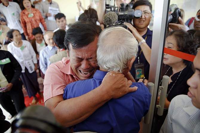 Soum Rithy (C), who lost his father and three siblings during the Khmer Rouge regime, breaks out in tears and hugs another survivor after the verdict was delivered in the trial of former Khmer Rouge head of state Khieu Samphan and former Khmer Rouge leader ''Brother Number Two'' Nuon Chea at the Extraordinary Chambers in the Courts of Cambodia (ECCC) on the outskirts Phnom Penh August 7, 2014. Photo: Reuters
