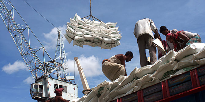 Men tends to unloading of sacks full of wheat from the cargo haul of a ship in the Chittagong port in Chittagong, Bangladesh. February 12, 2009. Photo: Getty Images