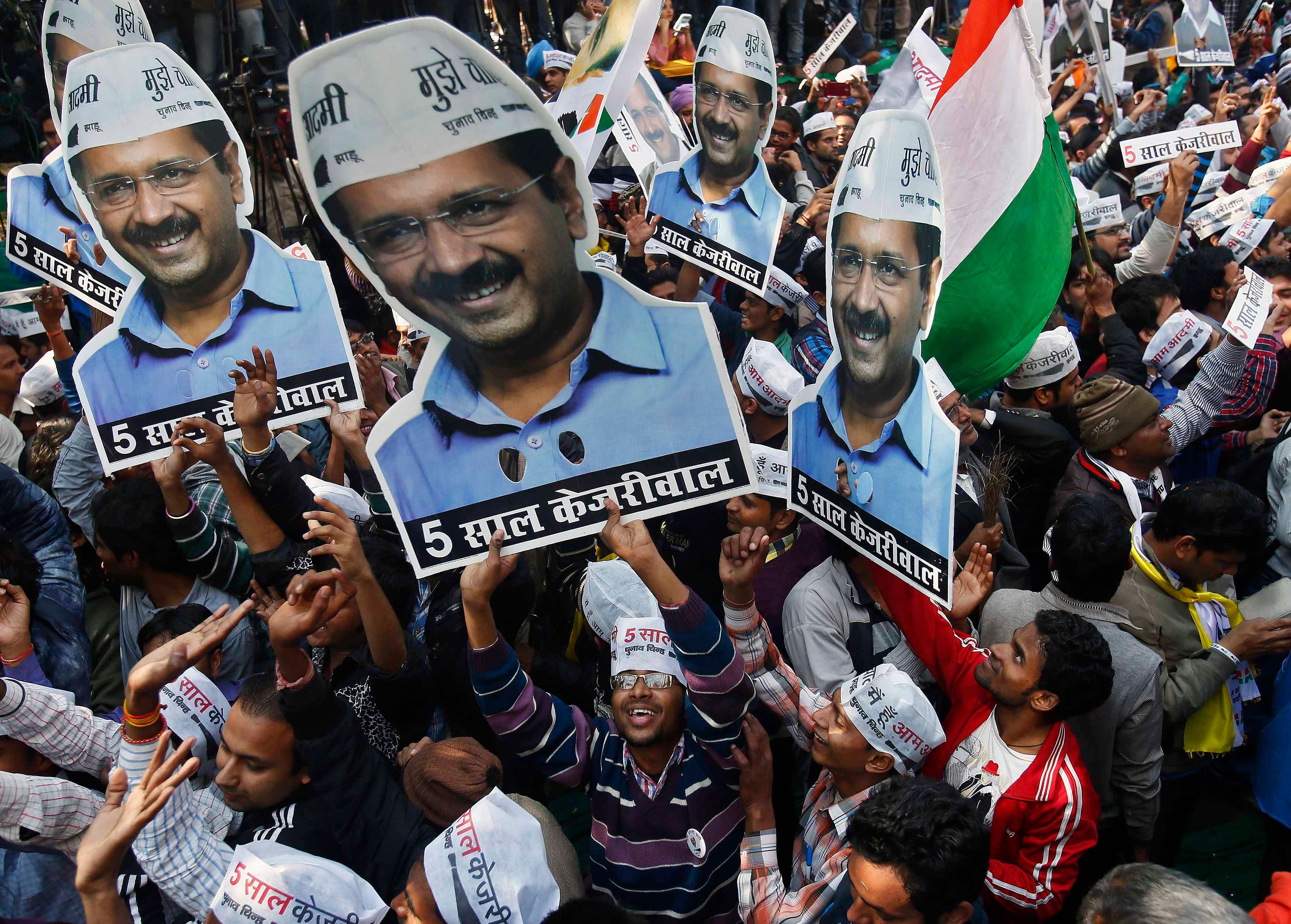 Supporters of Aam Aadmi (Common Man) Party (AAP) hold portraits of AAP chief and its chief ministerial candidate for Delhi, Arvind Kejriwal, during the celebrations outside their party office in New Delhi February 10, 2015. Photo: Reuters