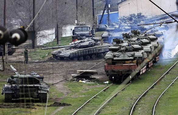 A Russian soldier (L) guides a Ukrainian tank, which is to be loaded onto a train, in northern Crimea March 27, 2014. Photo: Reuters