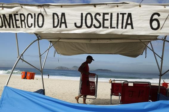 A man arranges beach chairs at his stall at Ipanema beach in Rio de Janeiro April 29, 2014. Photo: Reuters