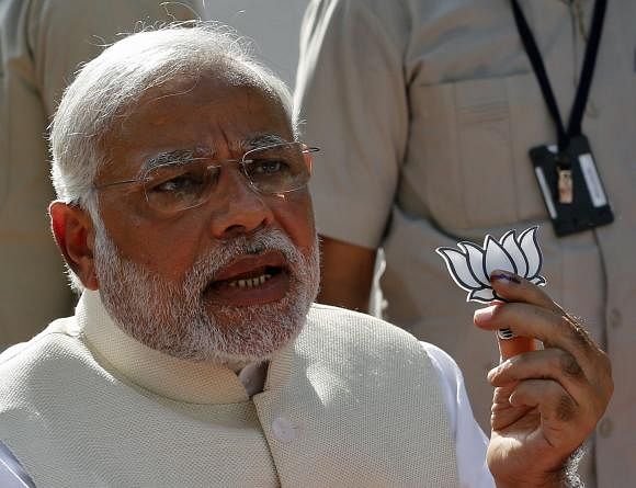 Hindu nationalist Narendra Modi, the prime ministerial candidate for India's main opposition Bharatiya Janata Party (BJP), holds a lotus cut-out after casting his vote at a polling station during the seventh phase of India's general election in the western Indian city of Ahmedabad April 30, 2014. Photo: Reuters