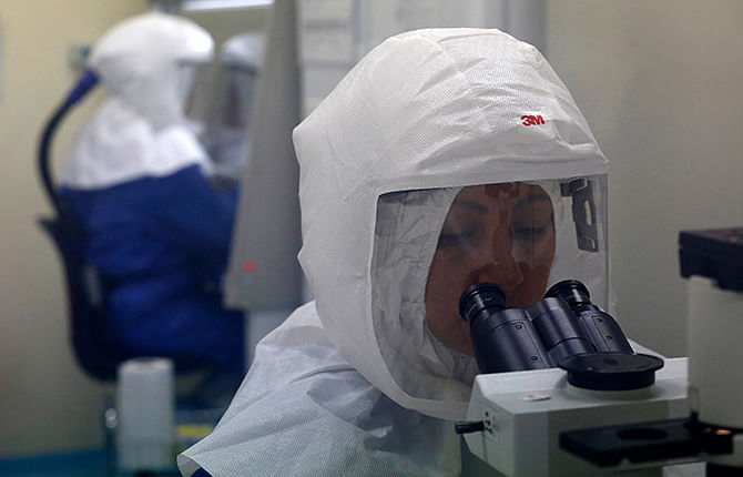 A doctor uses a microscope to look at virus samples in a Biosafety Level III laboratory at the National Institute of Health in Lima, August 12, 2014. Photo: Reuters