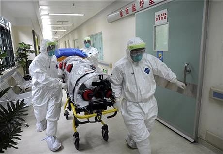 In this October 23, 2014 photo, medical workers wearing protective suits, handle a protective stretcher as they conduct a training exercise on dealing with suspected Ebola cases at a hospital in Guangzhou in south China's Guangdong province. Photo: AP