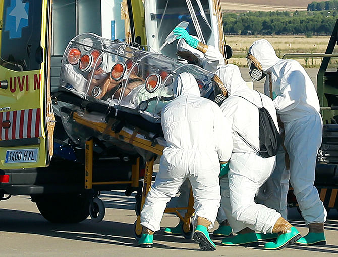 Health workers load Ebola patient, Spanish priest Miguel Pajares, into an ambulance on the tarmac of Torrejon airbase in Madrid, after he was repatriated from Liberia for treatment in Spain, August 7, 2014. Photo: Reuters